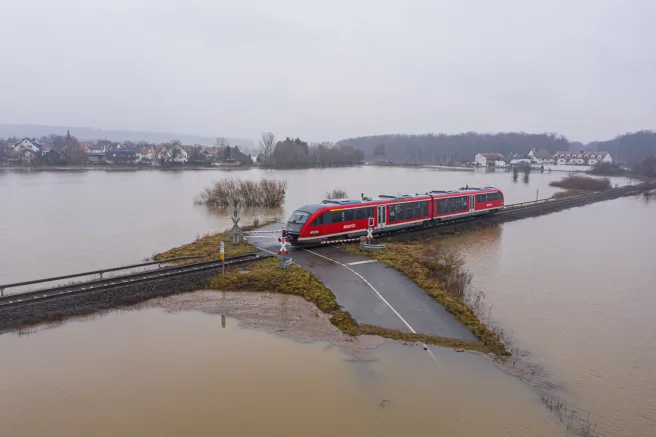 Tog kjører i et oversvømt landskap