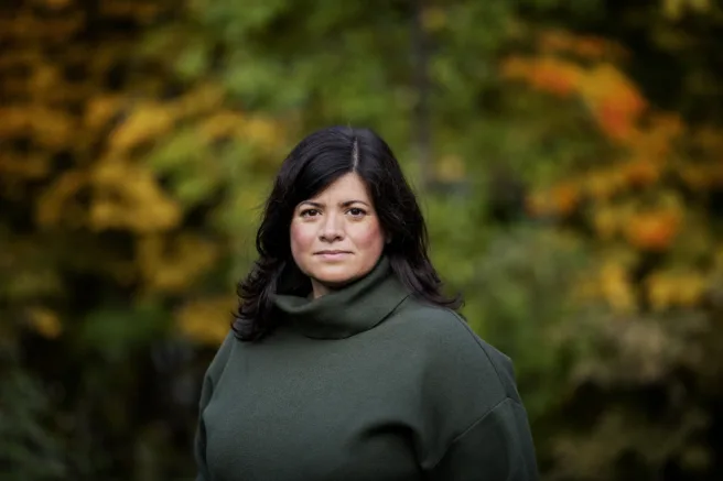Bilde av Karoline Andaur, generalsekretær i WWF Verdens naturfond. Hun står ute og i bakgrunnen er det grønn og høstfarget natur.